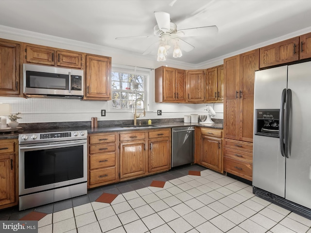 kitchen featuring stainless steel appliances, ornamental molding, sink, and ceiling fan