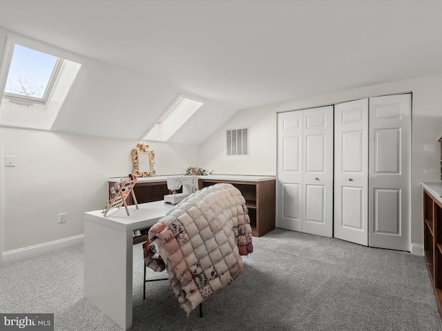 carpeted office featuring lofted ceiling with skylight