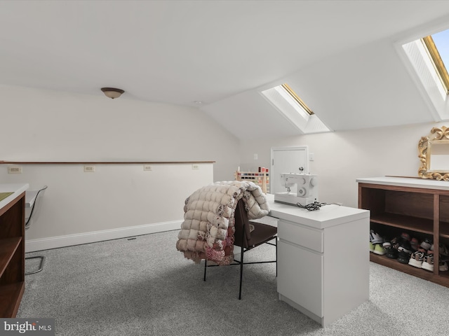 carpeted office with vaulted ceiling with skylight