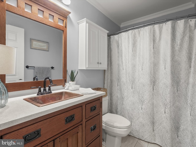 bathroom with vanity, crown molding, and toilet