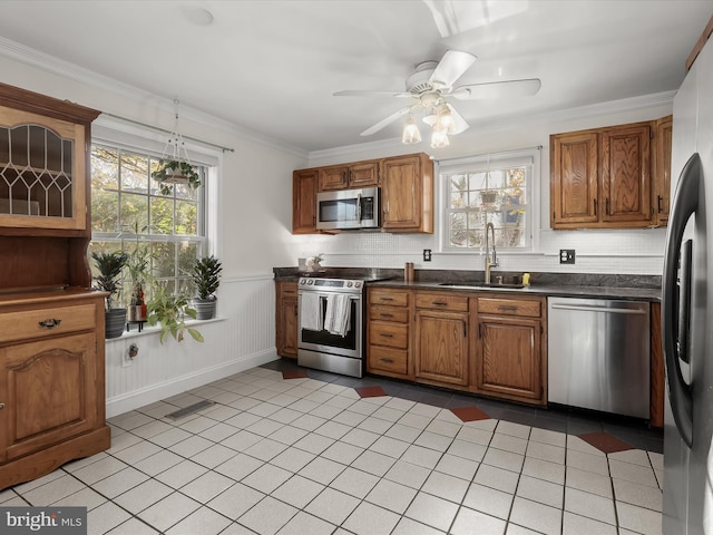 kitchen featuring crown molding, stainless steel appliances, sink, and plenty of natural light