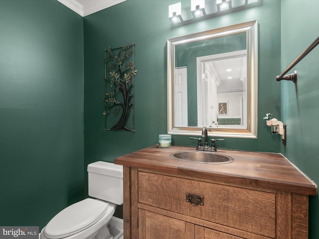 bathroom featuring vanity, ornamental molding, and toilet