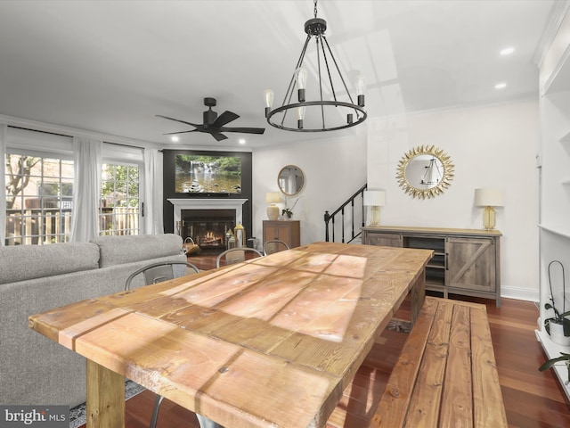 dining space featuring dark wood-type flooring and ceiling fan with notable chandelier