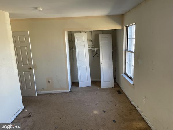 unfurnished bedroom with carpet floors and a closet