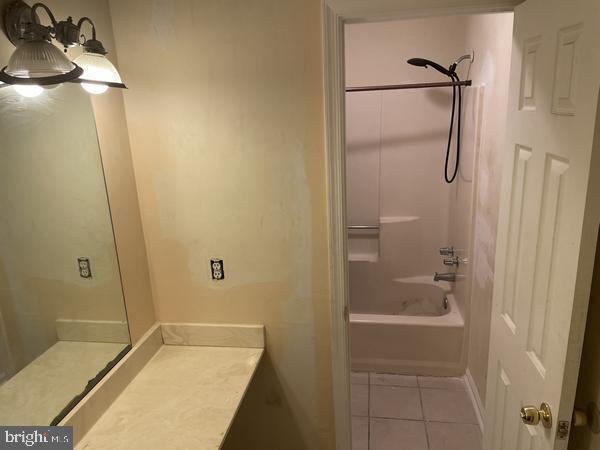 bathroom featuring tile patterned flooring, vanity, and shower / bathtub combination