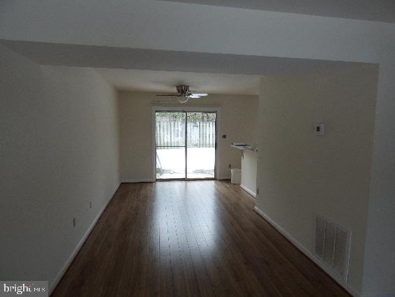 spare room with dark wood-type flooring and ceiling fan