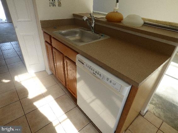 kitchen featuring sink, dishwasher, and light tile patterned flooring