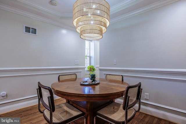 dining room featuring ornamental molding, dark hardwood / wood-style flooring, and a notable chandelier