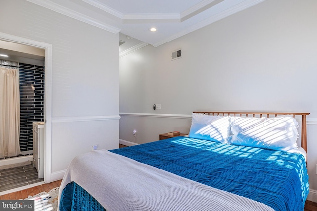 bedroom with ensuite bath, hardwood / wood-style flooring, and crown molding