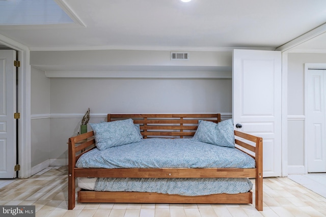 bedroom with light hardwood / wood-style floors and ornamental molding