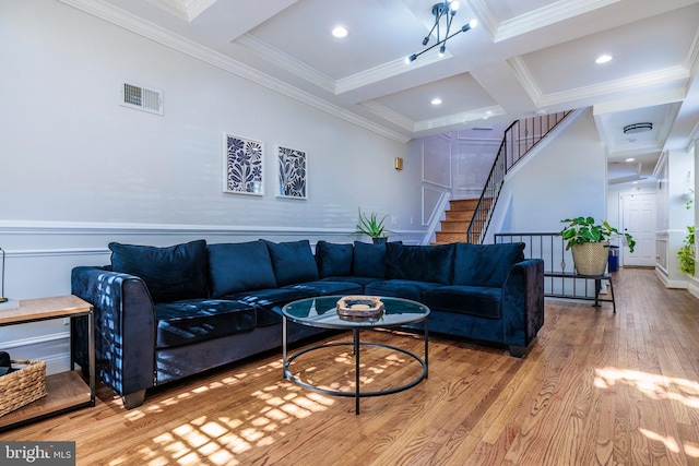 living room featuring coffered ceiling, beam ceiling, ornamental molding, and light hardwood / wood-style flooring