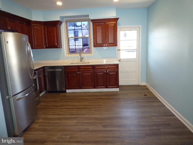 kitchen featuring appliances with stainless steel finishes, dark hardwood / wood-style flooring, sink, and a wealth of natural light