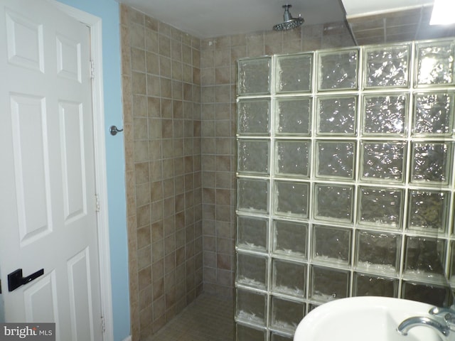 bathroom with a tile shower and sink