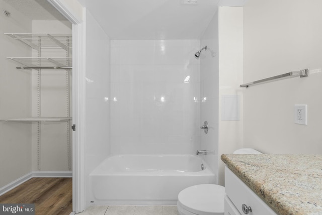 full bathroom with toilet, tiled shower / bath combo, vanity, and wood-type flooring