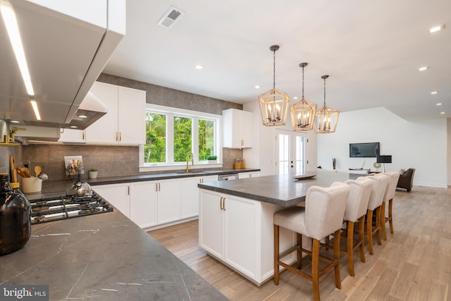 kitchen featuring island range hood, white cabinets, and light hardwood / wood-style floors