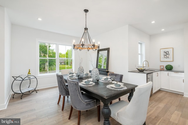 dining room with light hardwood / wood-style floors and a chandelier