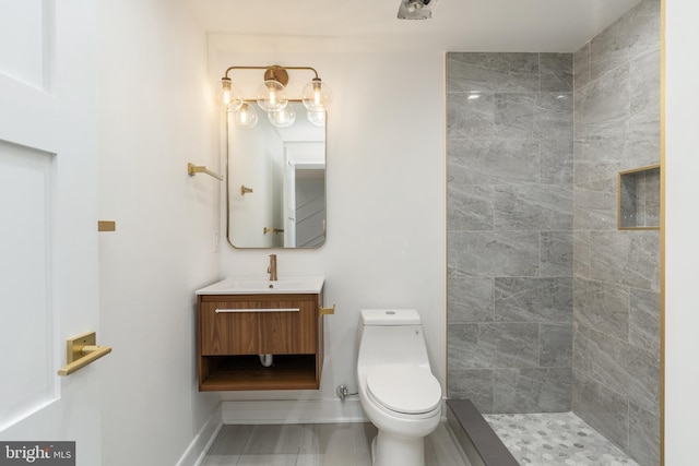 bathroom with vanity, toilet, and tiled shower