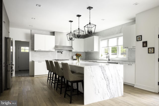 kitchen featuring a wealth of natural light, a center island, and white cabinetry