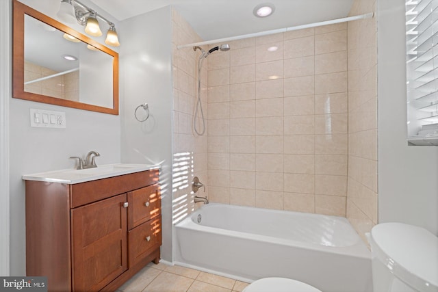 full bathroom featuring toilet, vanity, tiled shower / bath combo, and tile patterned floors