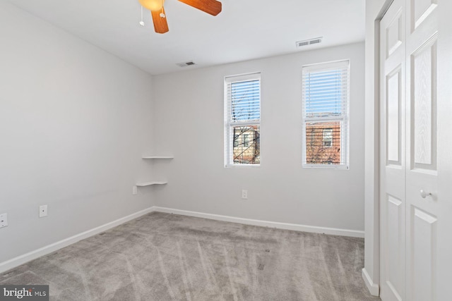 carpeted spare room featuring ceiling fan