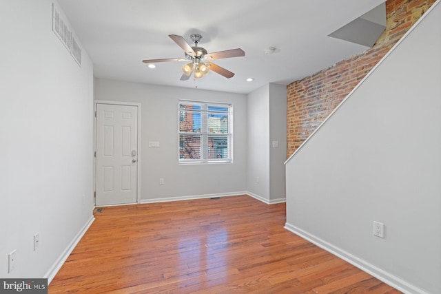 spare room with light wood-type flooring and ceiling fan