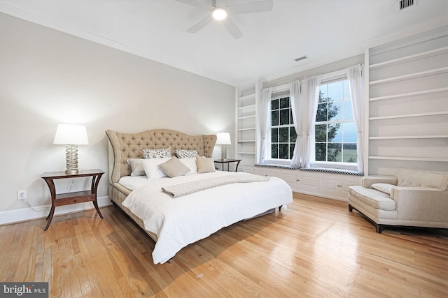 bedroom with ornamental molding, light wood-type flooring, visible vents, and baseboards