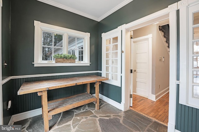 dining area featuring baseboards, wood finished floors, and crown molding