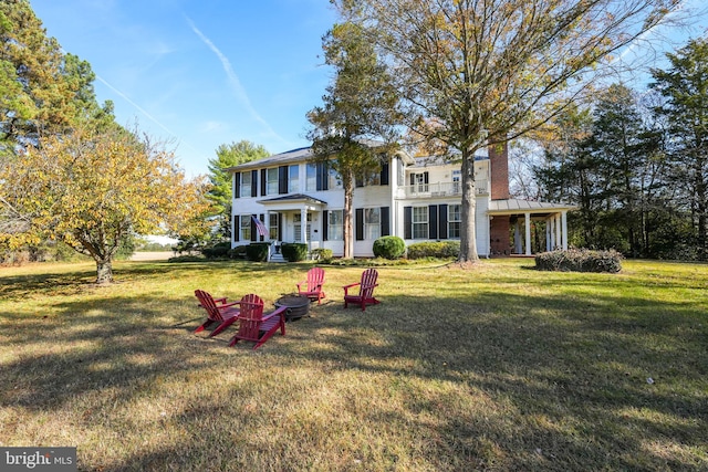 view of front facade with an outdoor fire pit and a front yard