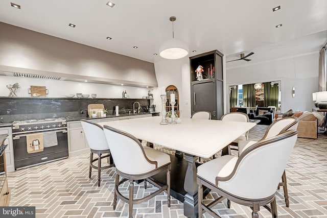 dining area featuring arched walkways, brick floor, and recessed lighting