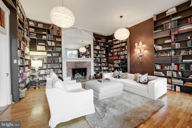 living room featuring a fireplace, bookshelves, and hardwood / wood-style floors