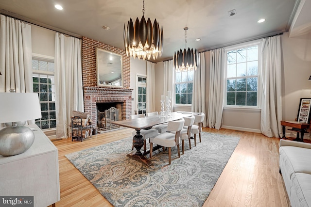 dining space featuring a chandelier, plenty of natural light, and wood finished floors