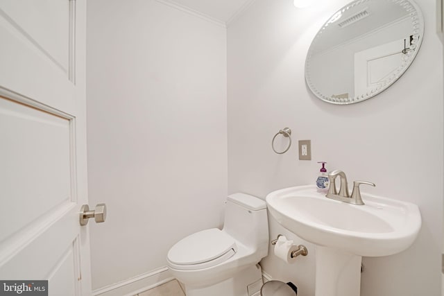 half bath featuring tile patterned flooring, toilet, visible vents, baseboards, and ornamental molding