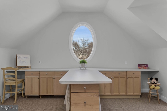 kitchen featuring carpet floors, vaulted ceiling, light brown cabinets, and light countertops