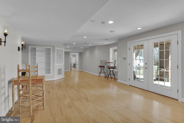 interior space featuring light wood-style floors, recessed lighting, french doors, and baseboards