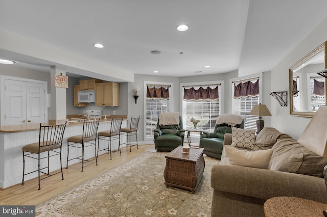 living area with recessed lighting, light wood-style flooring, and baseboards