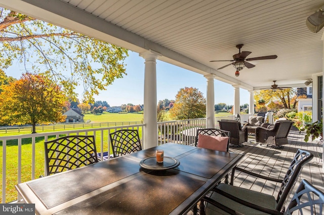 view of patio / terrace featuring ceiling fan, a rural view, an outdoor hangout area, and outdoor dining space