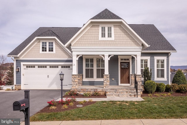 craftsman house featuring a garage, a front yard, and covered porch