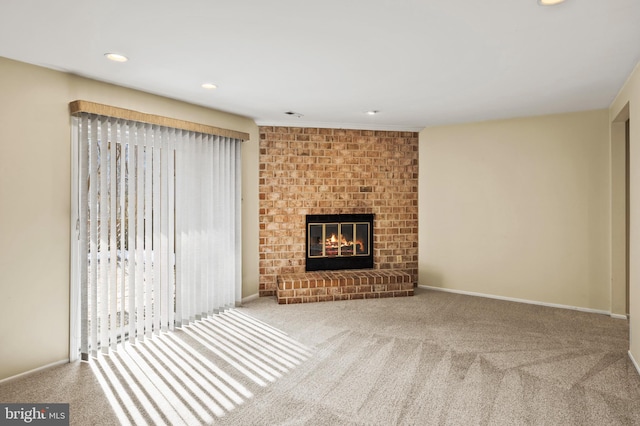 unfurnished living room featuring a brick fireplace and carpet