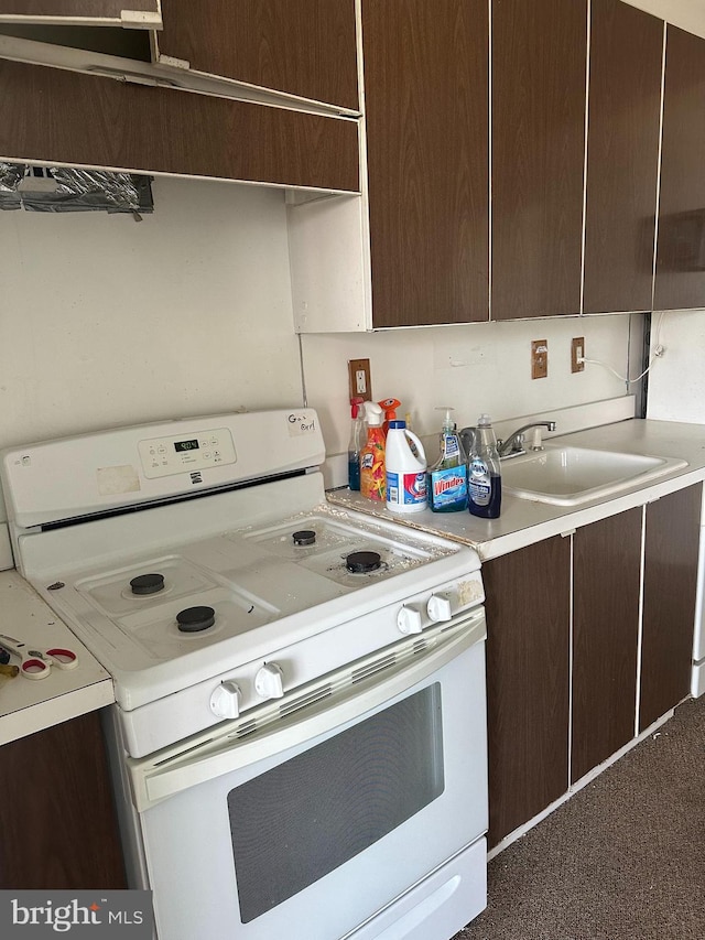 kitchen featuring sink, white range, and dark brown cabinets