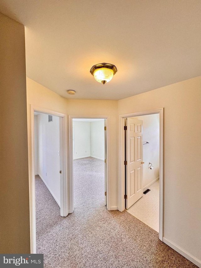 hall featuring light colored carpet