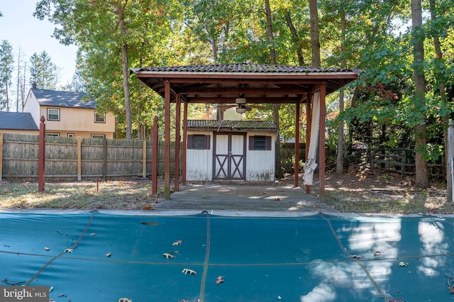 view of swimming pool with a shed and ceiling fan