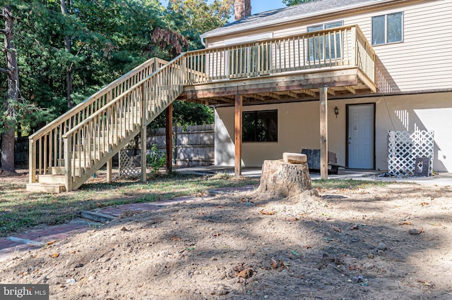 back of house with a wooden deck and a patio area