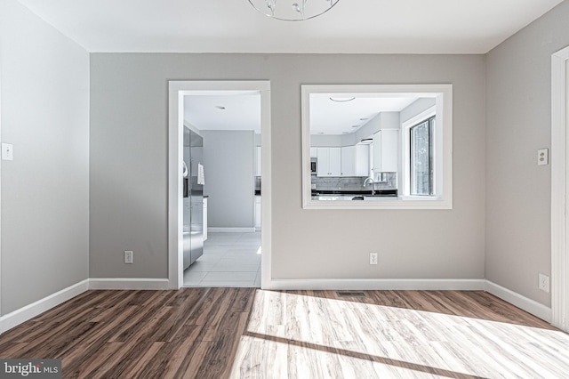 spare room with hardwood / wood-style flooring and sink