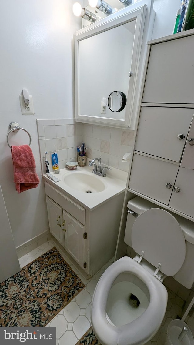 bathroom featuring vanity, backsplash, toilet, and tile patterned flooring