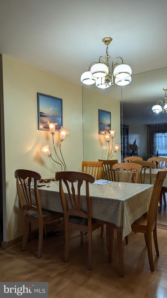 dining room with wood-type flooring and a notable chandelier