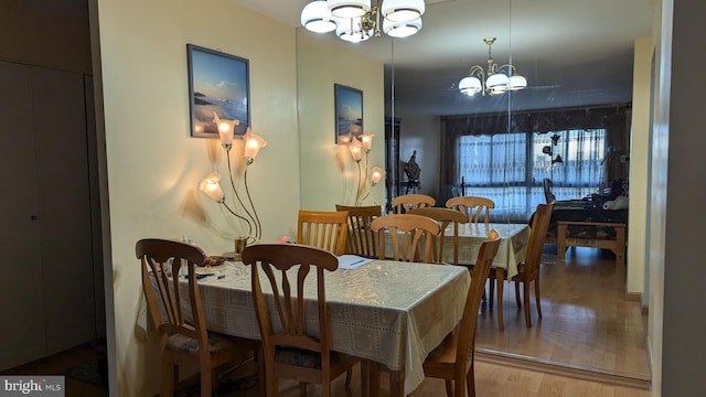 dining room with hardwood / wood-style floors and an inviting chandelier