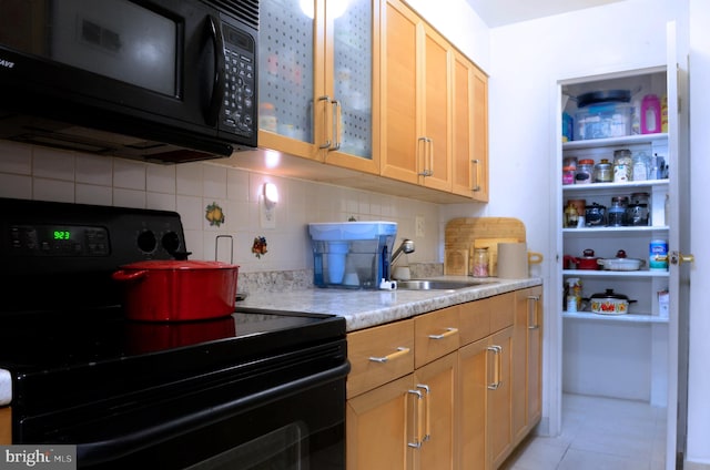 kitchen featuring light tile patterned floors, sink, tasteful backsplash, and black appliances