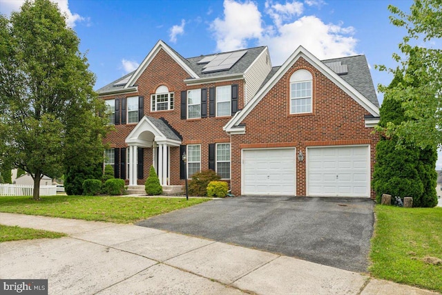 colonial-style house featuring a front yard and a garage