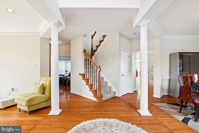 entryway with ornamental molding and hardwood / wood-style flooring