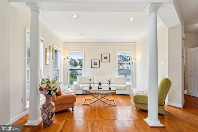 living room with ornate columns, hardwood / wood-style flooring, and ornamental molding